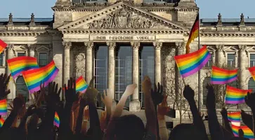 Bild: Reichstagsgebäude: Thomas Woodtli, Wikimedia Commons, CC BY-SA 2.0; Regenbogen-Hände: Freepik; Komposition: Wochenblick / Eigenes Werk