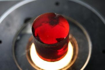 Frisch aus der Schmelze erstarrte Zinkoxid-Kristalle schimmern rot, weil sie noch atomare Defekte enthalten. Ein nachfolgendes Tempern - Erhitzen auf ca. 1000°C - bringt die Defekte zum Verschwinden und liefert ein blassgelbes Material, das zu Halbleiter-Wafern verarbeitet wird. Foto: IKZ