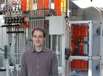 Dr. Hauke Marquardt, Leiter der neuen Emmy Noether-Nachwuchsgruppe im Bayerischen Geoinstitut (BGI), vor dem Hydrauliksystem einer Hochdruckpresse (rechts im Bild).