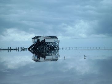 Pfahlbau am Strand bei Hochwasser, nach Beginn der Ebbe