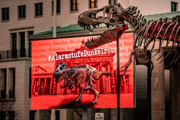 Mahnwache mit original T-Rex-Skelett vor dem Brandenburger Tor.  Bild: "obs/Dinosaurier Museum Altmühltal/MANUEL WEIDT"