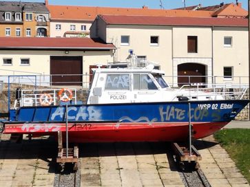 Unbekannte Täter beschmierten ein auf einem Trockendock auf einem Grundstück des Wasserstraßen- und Schifffahrtsamt Dresden in Pieschen liegendes Polizei-Boot mit Parolen wie 'ACAB' und 'Hate Cops'.  Bild: "obs/AfD - Alternative für Deutschland"