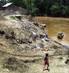 Überreste von weggeschwemmten Häusern am Flußufer. Bild: Caritas international