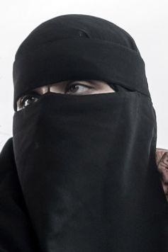 Niqab mit Nasensteg an einem Stirnband befestigt. Über einem Hidschab getragen
