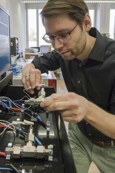 Forschung am Wasser-Elektrolyt: Empa-Forscher Ruben-Simon Kühnel schliesst eine Test-Zelle mit der konzentrierten Salzlösung ans experimentelle Ladegerät an. Quelle: Empa (idw)