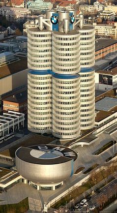 „Vierzylinder“ – BMW-Hauptsitz in München vom Olympiaturm aus gesehen, davor das schüsselförmige BMW-Museum. Bild: Markus Matern  / wikipedia.org