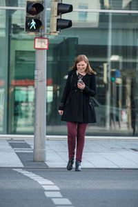 Frau mit dem Handy in der Hand: bringt sich in Lebensgefahr. Bild: dekra.de