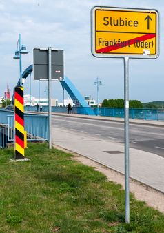 Grenzpfahl und Ortsschild auf der deutschen Seite