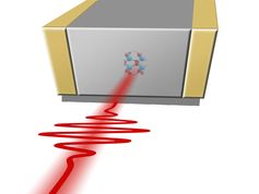 Ein Laserpuls trifft ein Stück Quarzglas zwischen zwei Elektroden.