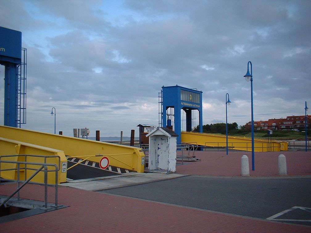 Anleger im Wittdüner Fährhafen. Rechts im Hintergrund Wohnhäuser auf der Amrumer Südspitze