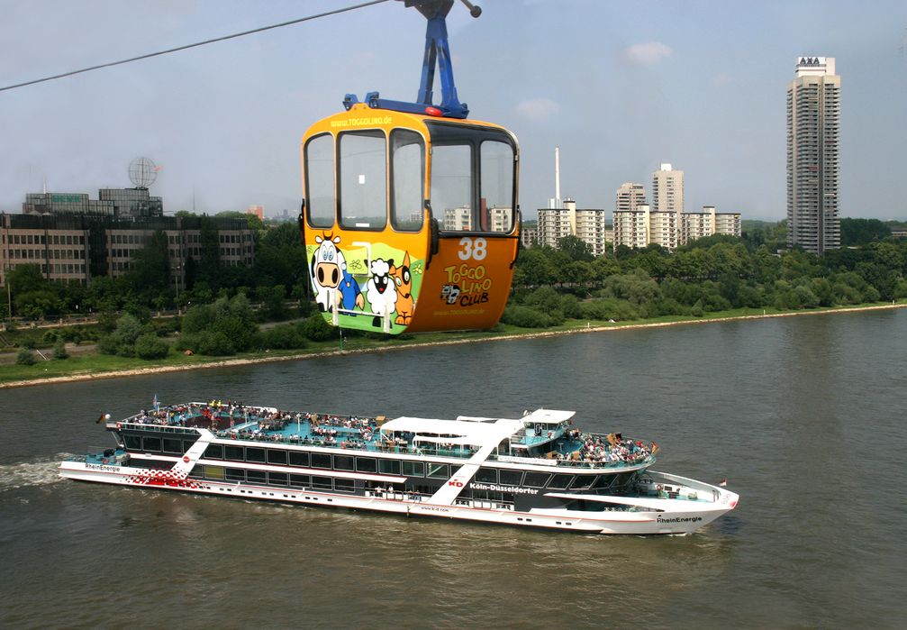 Seilbahn-Gondel während der Fahrt. Am Rheinufer das Colonia-Hochhaus