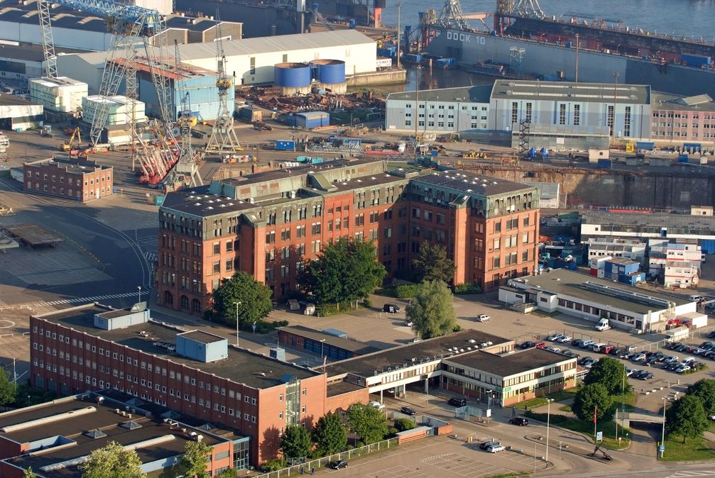 Werksgelände von Blohm + Voss: vorne die Einfahrt, mittig das Verwaltungsgebäude, rechts dahinter das Trockendock Elbe 17, oben rechts Dock 10