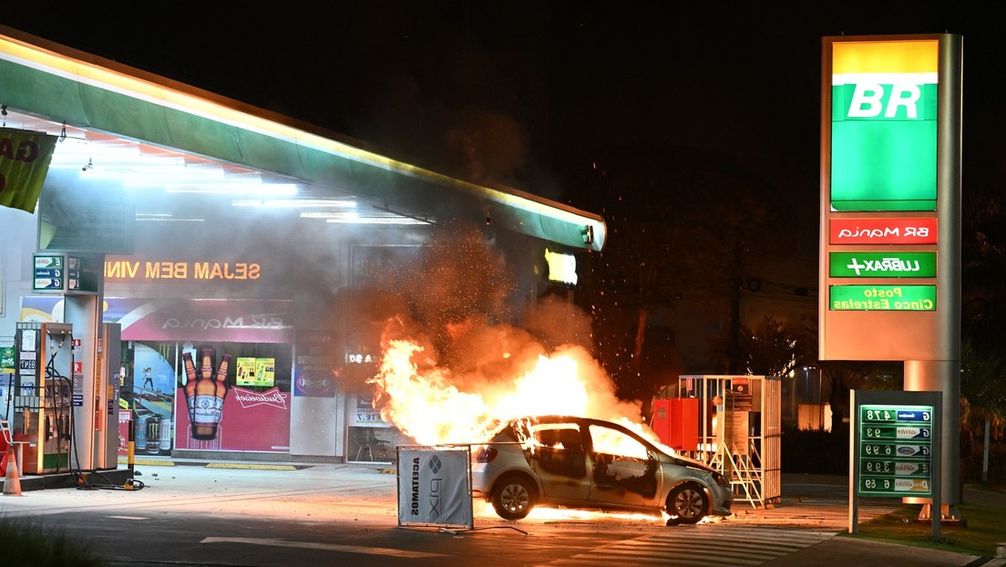 Ein Auto brennt an einer Tankstelle infolge von Prostesten in Brasília, 12. Dezember 2022.