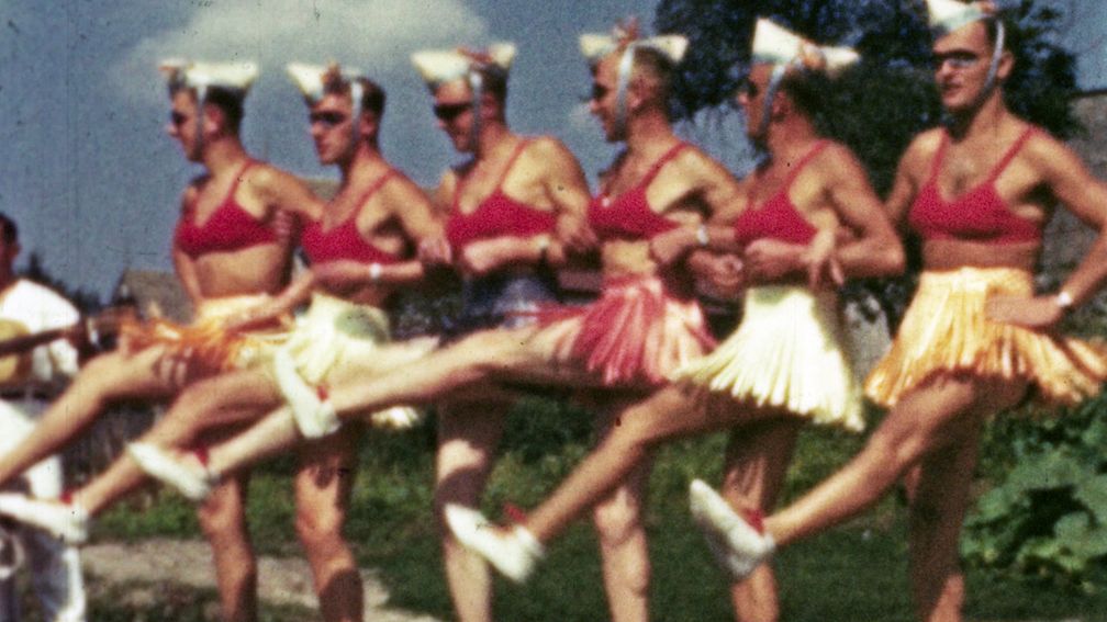 Ein Oberfeldarzt filmt an der Ostfront Soldaten in Baströckchen, die ihre Kameraden in einer Kampfpause mit Tanzeinlagen unterhalten.  Bild: "obs/ZDF/Heinz Schünemann"