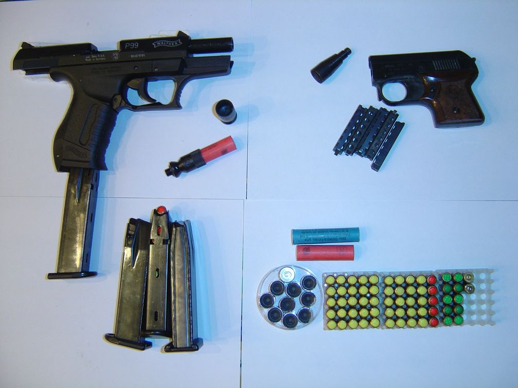 Schreckschusspistolen Walther P99 (l.) und Röhm Mod. 3S (r.), Patronen (blau = CN, gelb = CS, rot = Pfeffer und sonstige Reizstoffe, grün = Platz) und Signalmunition