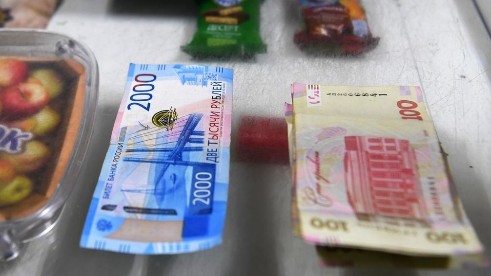 Eine russische Rubel-Banknote (links), eine ukrainische Griwna-Banknote (rechts), das Gebiet Saporoschje (Archivbild) Bild: RIA Nowosti / Sputnik