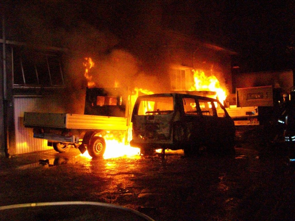 Brennender Kleintransporter vor der Lagerhalle.