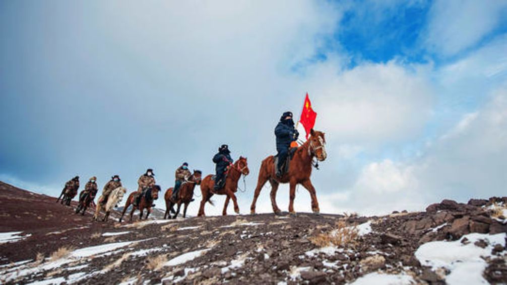 Berittene Polizisten und Grenzschutzbeamte patrouillieren auf den Höhenzügen im Landkreis Mulei im Nordwesten des Uigurischen Autonomen Gebiets Xinjiang.