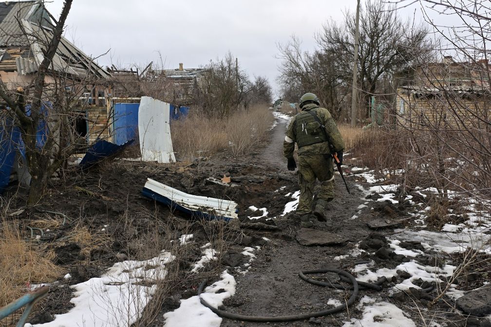 Ein russischer Armeeangehöriger in der Ortschaft Marjinka, die durch Artillerie-Angriffe beschädigt wurde, 25. Februar 2023. Bild: JEWGENI BIJATOW / Sputnik