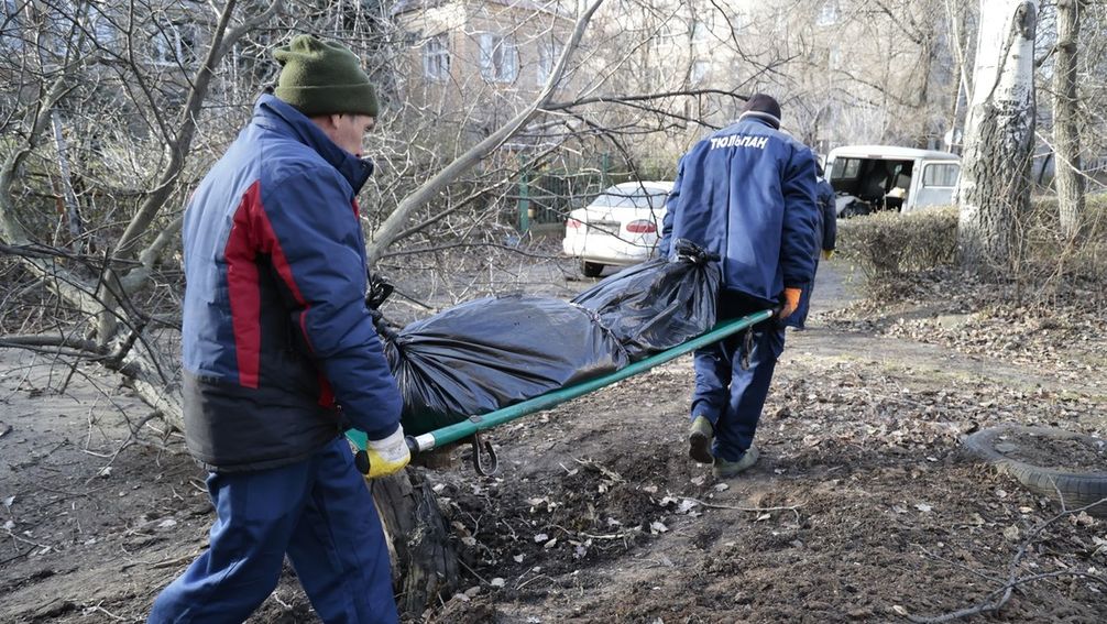 Archivbild: Versorgungsarbeiter tragen die Leiche eines Mannes, der durch den Beschuss der ukrainischen Streitkräfte von Donezk getötet wurde. Bild: Sergei Awerin / Sputnik