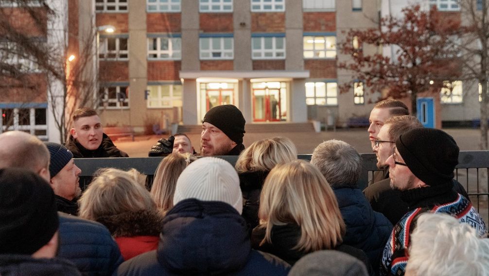 27. Februar 2023, Mecklenburg-Vorpommern, Greifswald: Bürger stehen vor dem geschlossenen Eingang der Schule "Caspar David Friedrich". Hier befasst sich die Sitzung der Bezirksvertretung Ostseeviertel mit dem geplanten Bau einer Unterkunft für 500 Flüchtlinge. Bild: www.globallookpress.com / Markus Scholz