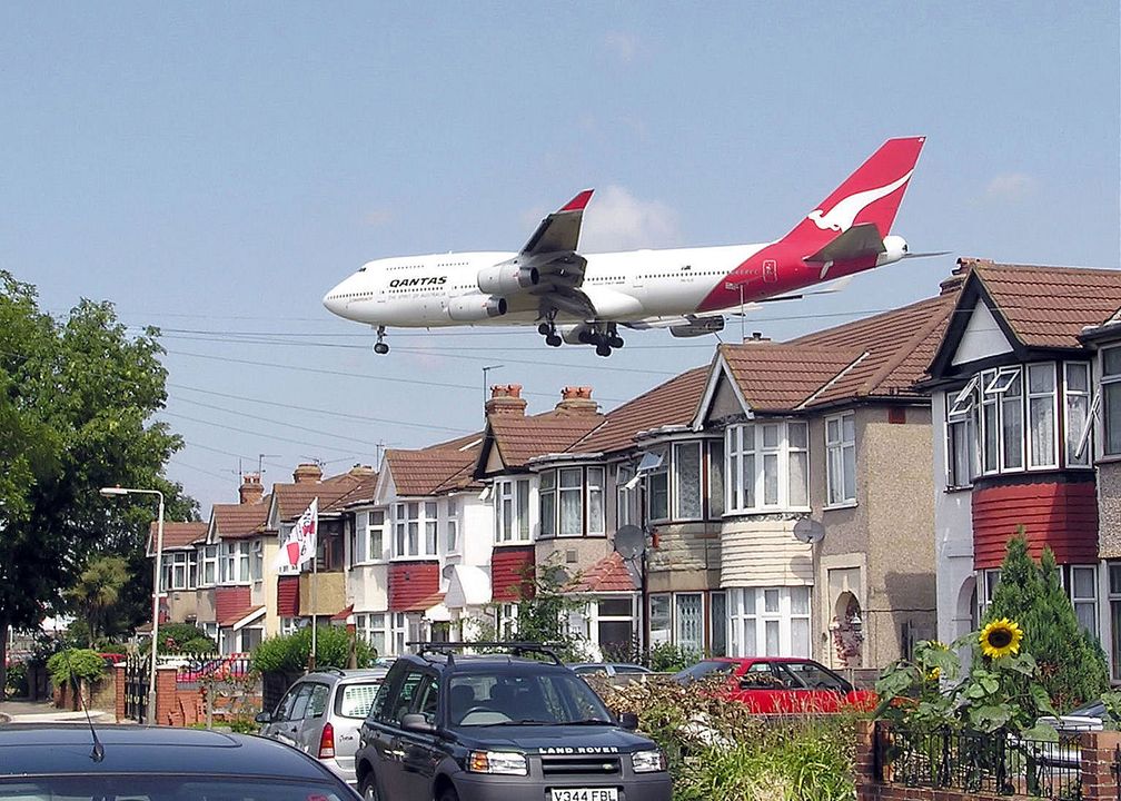 Eine Boeing 747–400 knapp über den Häuser im Landeanflug.