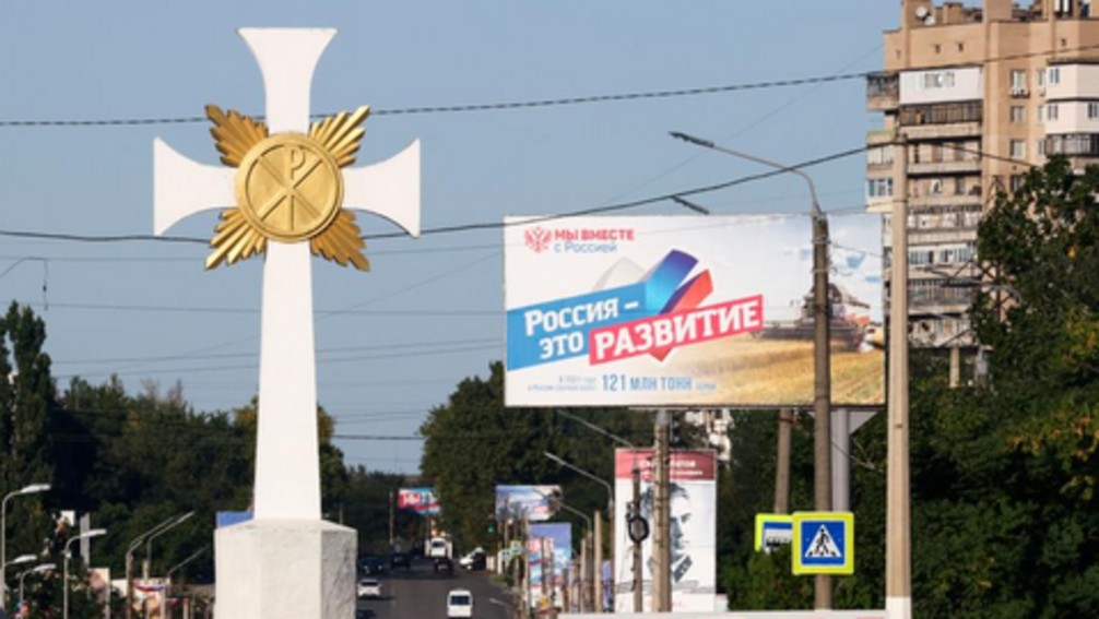 Straßenszene mit Plakat "Wir sind zusammen mit Russland" (Screenshot) Bild: Сергей Мальгавко/ТАСС / https://tass.ru/mezhdunarodnaya-panorama/15688775 / RT