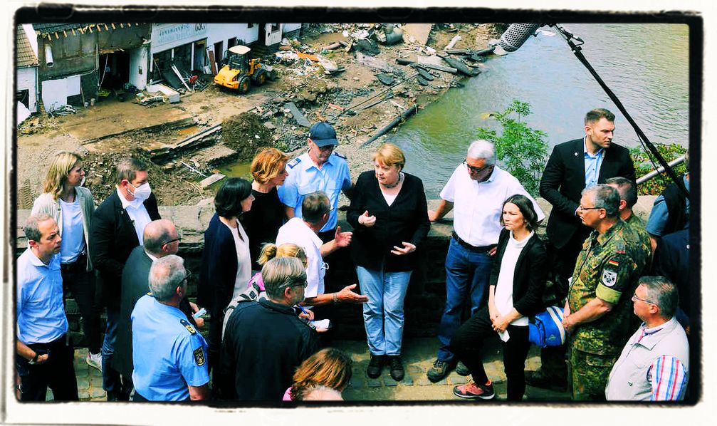 Bundeskanzlerin Angela Merkel (3. v. l., 1. Reihe) und die rheinland-pfälzische Ministerpräsidentin Malu Dreyer (5. v.rl., 1. Reihe) sprechen bei ihrem Besuch in den vom Hochwasser betroffenen Gebieten mit Betroffenen. Bild: Eigenes Werk /SB