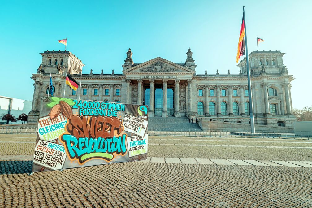 Protest im Berliner Regierungsviertel: 240.000 Stimmen unterstützen die Kampagne Sweet Revolution und fordern mehr Fairness im Kakaosektor. Bild: "obs/TransFair e.V./Florian Gruendig."