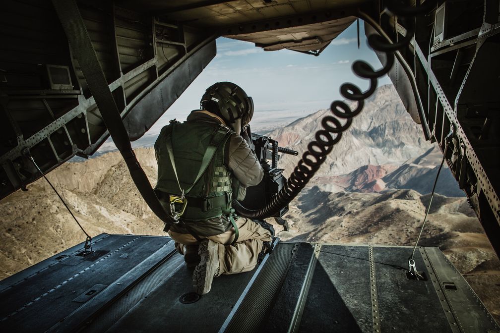 Ein Bordsicherungssoldat ("Doorgunner") beobachtet das Gelände während eines Fluges mit dem Transporthubschrauber CH-53 im Rahmen der Mission Resolute Support in Afghanistan, am 03.11.2019. Bild: Bundeswehr/Jana Neumann Fotograf: Tobias Wolf