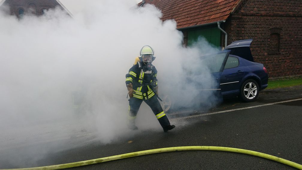 Eingeschränkte Sicht durch Rauch und Wasserdampf während der Löscharbeiten. Der Truppmann steht nicht erkennbar in der Rauchwolke, weshalb der schwere Atemschutz sehr sinnvoll ist. Bild: Feuerwehr