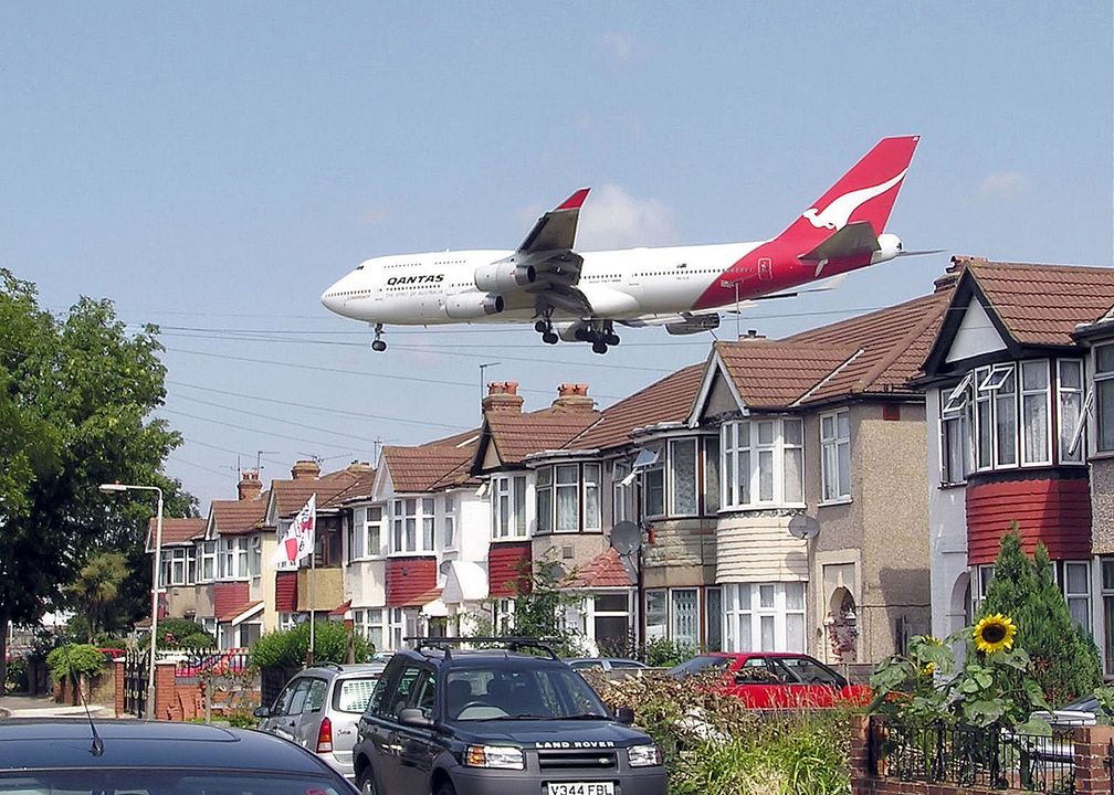 Eine Qantas Boeing 747–400 passiert knapp die Häuser in der Nähe des London Heathrow Airport.
