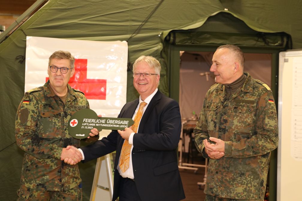 Der Abteilungsleiter "Land-Unterstützung" im BAAINBw, Jan Gesau (Mitte), übergibt den symbolischen Schlüssel an den stellvertretenden Inspekteur  des Sanitätsdienstes, Generalstabsarzt Dr. Norbert Weller (links) im Beisein des Abteilungsleiters "Ausrüstung" im BMVg, Vizeadmiral Carsten Stawitzki (rechts).