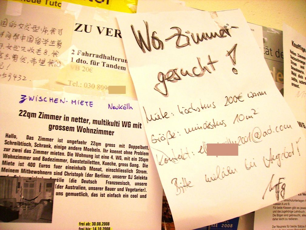 WG-Zimmer-Angebote und -Gesuche an einem schwarzen Brett in Berlin