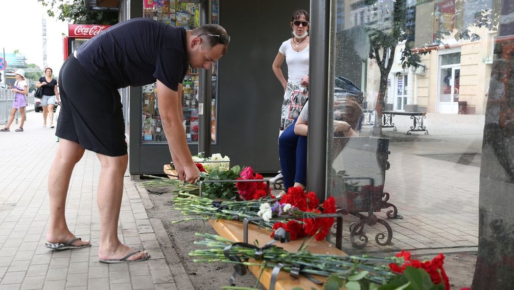 Ein Mann legt am 13. August 2021 am Ort der Tragödie in Woronesch Blumen nieder, um der Todesopfer zu gedenken.