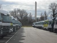 Neu produzierte Mercedes-Lkw auf einer Abstellfläche beim Hafen Wörth. Im Hintergrund der Kamin des zum Werk gehörigen Kraftwerks