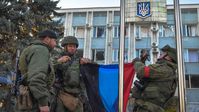 Soldaten der DVR-Volksmiliz hissen die Nationalflagge der Donezker Volksrepublik vor der Stadtverwaltung in Wolnowacha.