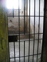 Gefängnis, Gefängniszelle, Gefangener und hinter Gittern (Symbolbild)