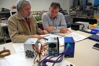 Professor Dr. Ewgeni Komarov und Dr. Alexander Kirjuchin (v. l.) haben ein neues, effizientes Netzteil für Personal Computer entwickelt. Im Vordergrund rechts ein Prototyp