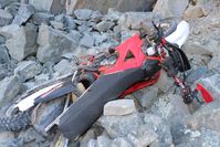 Die Crossmaschine stürzte auf ein Steinfeld unterhalb der Klippe. Der Fahrer lag beim Auffinden auf dem Motorrad. Bild: Polizei