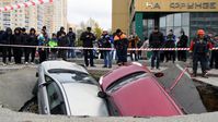 Am 13. Oktober 2021 verschluckt die Erde zwei Autos auf einem Parkplatz in Nowosibirsk. Bild: Sputnik / ALEXANDER KRJASCHEW