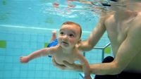 Tauchender Säugling beim Babyschwimmen