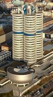 „Vierzylinder“ – BMW-Hauptsitz in München vom Olympiaturm aus gesehen, davor das schüsselförmige BMW-Museum. Bild: Markus Matern  / wikipedia.org