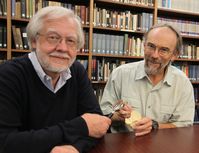 Prof. Dr. Dr. Michael Schultz betrachtet das Schädelstück des Homo erectus in Prof. John Kappelmanns Händen mit der Lupe.
Quelle: Foto: umg (idw)