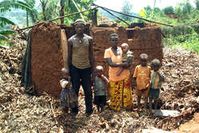 Eine Batwa-Familie vor ihrem Haus. Das Dach wurde im Zuge der Kampagne gegen Strohdächer von den Behörden Ruandas entfernt. Bild: COPORWA/Survival