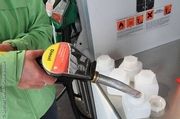 Greenpeace nimmt Proben von Diesel Kraftstoff an einer Tankstelle. Der Anteil von Diesel aus Palmöl als Teil von Agrosprit soll gemessen werden. Sie füllt Diesel mit einer Zapfpistole in Testbehälter. © Steffen Giersch/Greenpeace 