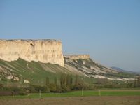 Blick auf den Ak-Kaya-Felsen. Die von den späten Neandertalern genutzten Felschutzdächer befinden sich knapp unterhalb der Hochfläche und sind heute von Hangschutt bedeckt.