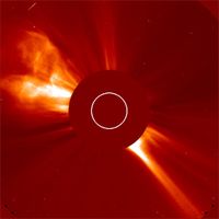 Abb. 1: Aufnahme einer Sonneneruption mit dem Koronagraphen LASCO an Bord der Sonnensonde SOHO. Die Sonne verbirgt sich hinter der Scheibe, ihre Lage und Größe sind durch den Kreis angedeutet. Bild: Max-Planck-Institut für Sonnensystemforschung