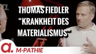 Bild: SS Video: "M-PATHIE – Zu Gast heute: Thomas Fiedler – “Die Krankheit des Materialismus”" (https://tube4.apolut.net/w/p5bKerQVj9xgy2cknSHj1G) / Eigenes Werk