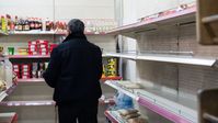 Auf dem Archivbild: Ein Mann steht vor fast leeren Lebensmittelregalen in einem Geschäft in Stepanakert im Bergkarabach, 28. Dezember 2022. Bild: Sputnik / DAWID KAGRAMANJAN